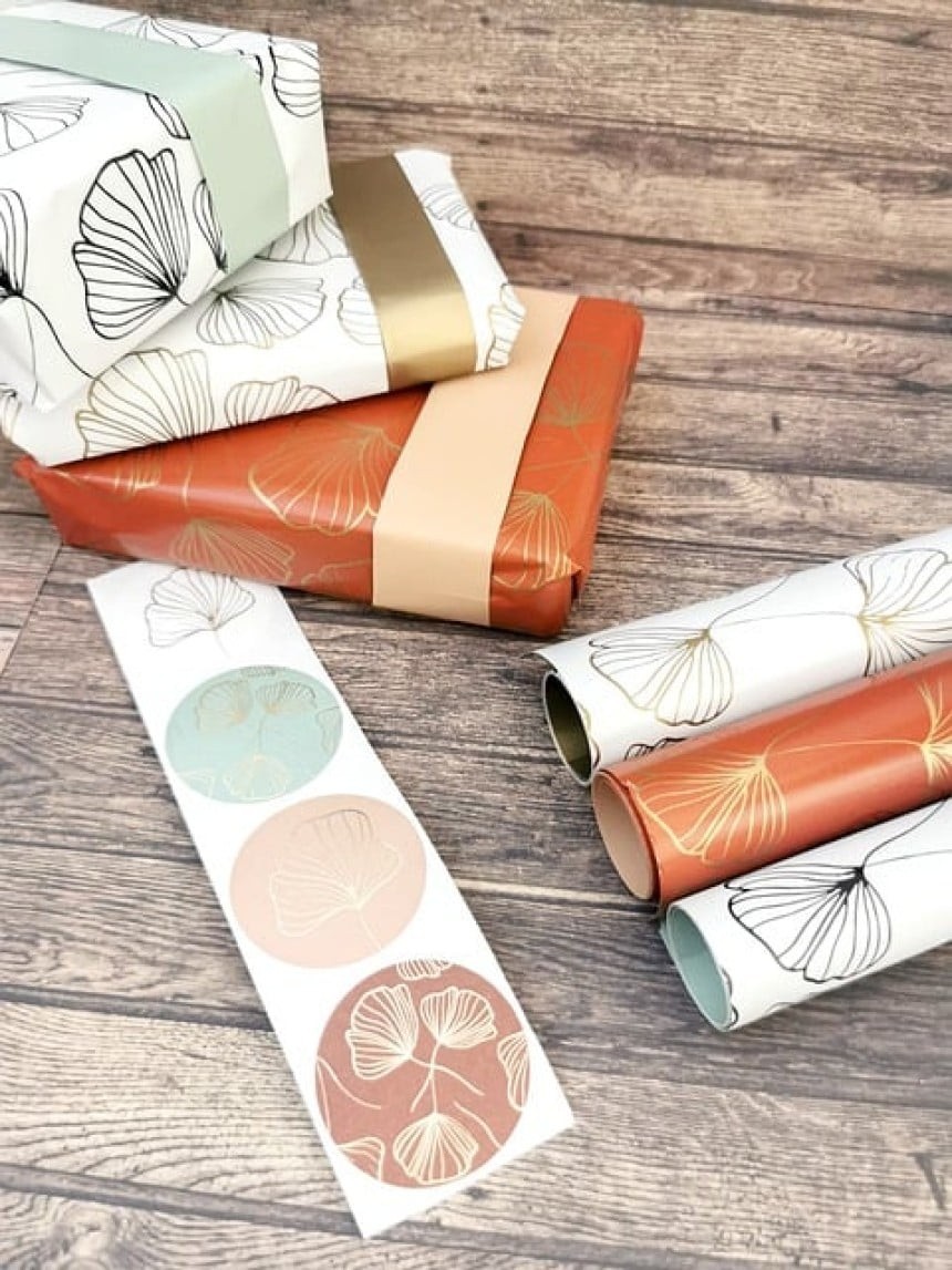 darila-7973160 640 Na sliki je več daril, zavitih v več različnih zavijalnih papirjev različnih barv in vzorcev. Zraven so tudi role papirja za zavijanje in okrogle nalepke različnih barv in vzorcev.